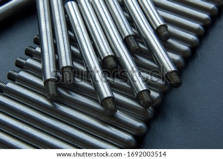The turned parts on the production table in a row against a dark background. The manufacture of axles in the factory.