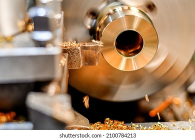 A turner makes a bronze bushing on a lathe by removing chips with a mechanical cutter.