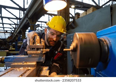 Turner, male-female workpiece He is turning work in a blue jumpsuit and wearing a safety hard hat. - Powered by Shutterstock