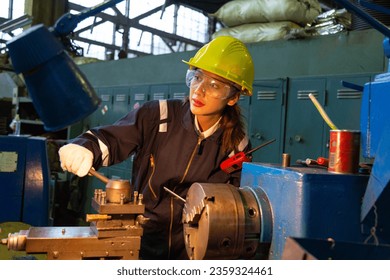 Turner, male-female workpiece He is turning work in a blue jumpsuit and wearing a safety hard hat. - Powered by Shutterstock