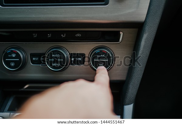 Turning the air conditioning on in the car. The\
concept of caring for comfort, lowering the temperature in the car\
on hot days. The driver turns on the air conditioning system in his\
car.