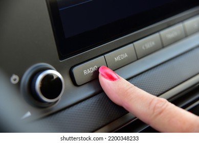 Turning On The Car Radio. A Woman's Finger On The Button To Turn On The Car Radio. 