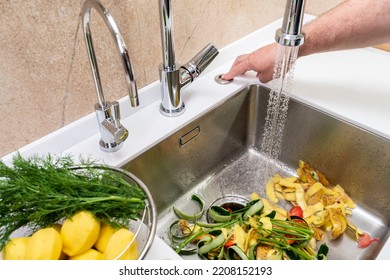 Turning on a disposer in a modern kitchen to remove food waste - Powered by Shutterstock