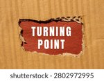 Turning point text appearing through a torn corrugated cardboard surface, symbolizing change, decision, and new direction