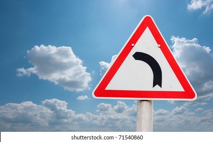 Turning road sign against blue sky