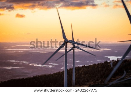 Turning wind power plant during sunrise on a mountain in Austria