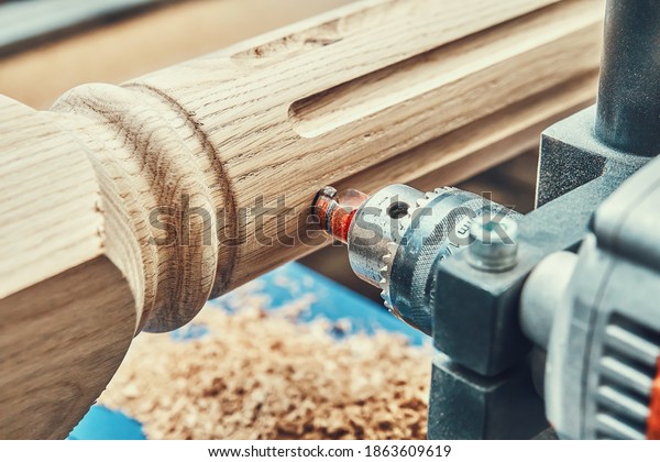 Turning\
wooden stair balusters. Wood stair balusters manufacturing process\
on a turning lathe with milling cutter.\
Close-up