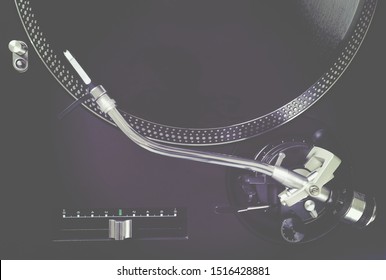 Turntable with black record and headshell, closeup top view