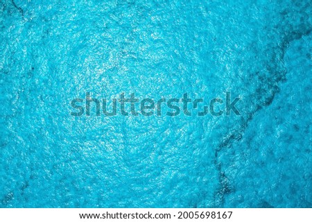 Turqoise blue sea texture with waves and foam. Carribean colors. Background sea photo.
