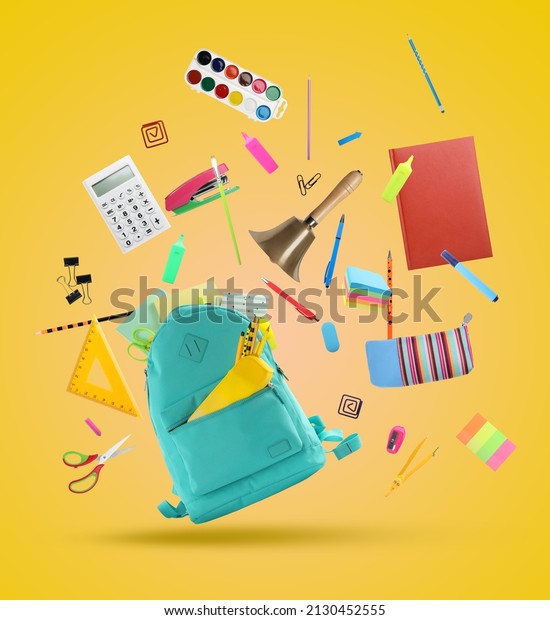 Turquoise backpack, school bell and different\
stationery flying on yellow\
background