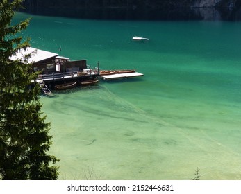 Turquoise blue mountain lake - Pragser Wildsee - closeup with jetty and boats in the sunshine
