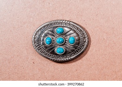 Turquoise buckle on wooden background.