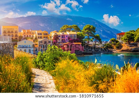 Turquoise colored bay in Mediterranean sea with beautiful colorful houses in Assos village in Kefalonia, Greece. Town of Assos with colorful houses on the mediterranean sea, Greece. 