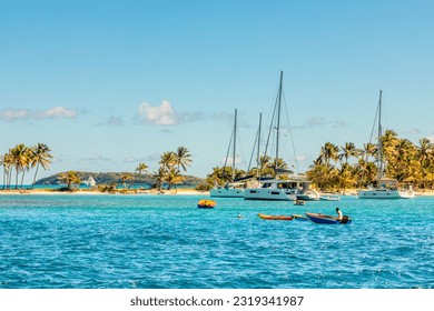 Turquoise colored sea with ancored yacht and boats, Tobago Cays, Saint Vincent and the Grenadines, Caribbean sea