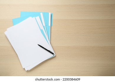 Turquoise files with blank sheets of paper and pen on wooden table, top view. Space for text - Powered by Shutterstock