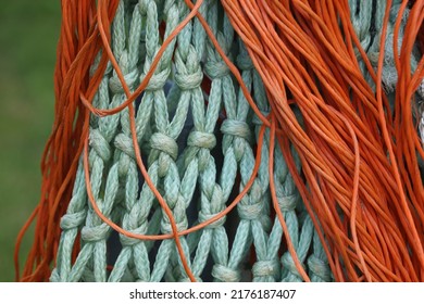 Turquoise Fish Net And Orange Plastic Lines Hanging Outside