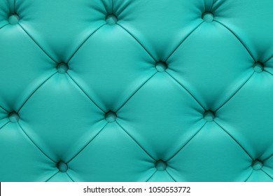 Turquoise leather sofa stitched buttons.