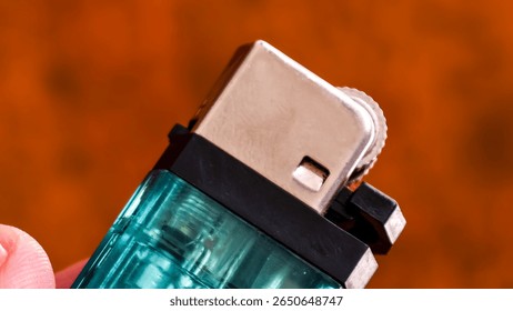 A turquoise lighter with metallic elements. The focus highlights the textured ignition wheel and the overall sleek design