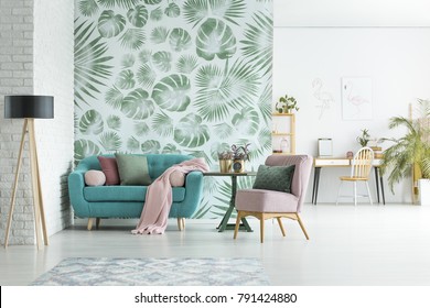 Turquoise Lounge With Pink Blanket And Pillows Standing In Stylish Apartment Interior With Floral Wallpaper