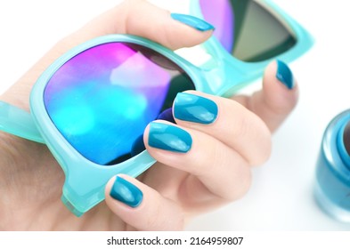 Turquoise manicured hands holding objects