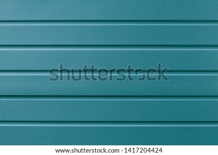Turquoise metallic striped surface. Metalline wall siding, cladding. Abstract green striated background, pattern. Blue metal fence with glitter, shine. Reflecting metal convex texture.