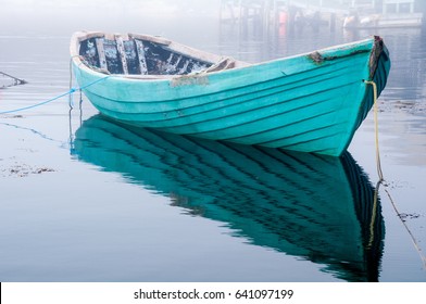 Turquoise Old Row Boat Tied  to Mooring on Foggy Morning