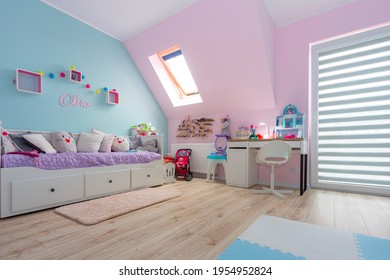 Turquoise and pink childrens room with a study desk and toys.