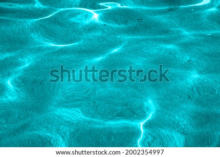 Turquoise Pure clear water in the sea, sun glare, waves and sea sand. Calm sea water background