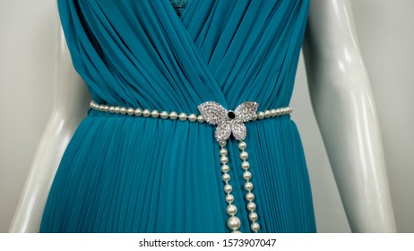 Turquoise Teal Gown Evening Dress on a white mannequin with white opaque pleated curtain background