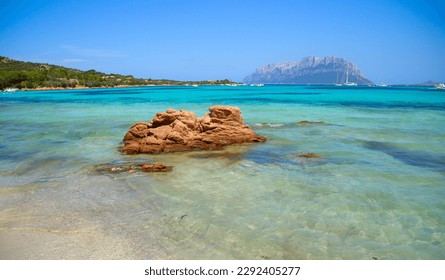 Turquoise translucent and shallow waters on the beach of Porto Istana near Olbia on the Costa Smeralda ("Emerald Coast") in Sardinia - View over the island of Tavolara in the Mediterranean Sea