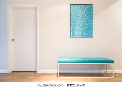 Turquoise, upholstered bench seat and a city map poster in a white house interior with wooden panels