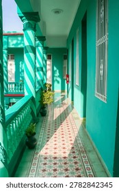 Turquoise veranda features patterned floor tiles and spiral columns in Camaguey, Cuba