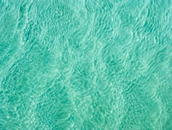 Turquoise Water Near To The Sand Underneath Forming Many Little Waves Reflecting The Sun, Thailand