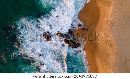 Turquoise water with wave with sand beach background rocks and corals from aerial top view in sunset. Concept summer