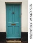 Turquoise wooden front door number 22 as seen in the UK