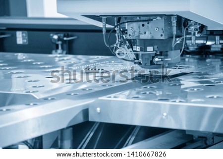 Turret punching machine cutting the metal  plate. Metal forming machine.