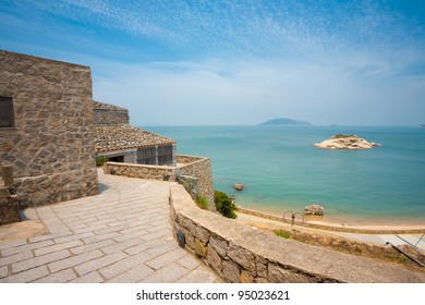 Turtle island, beach, ocean and blue sky seen from elevated viewpoint in the preserved beige stone village of Qinbi, the top tourist destination for Matsu islands in Beigan, Taiwan