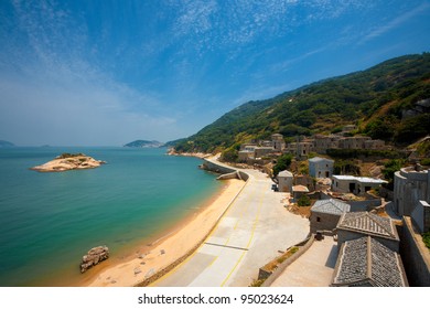 Turtle island off the coast of Qinbi village waterfront with beach and turquoise ocean water, a preserved beige brick town on Beigan Island, Matsu Islands in Taiwan. Copy space
