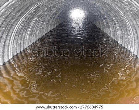 The Turtle River running through a huge culvert in the spring.  Murky brown water reflecting off the metal via the sun coming through the end of the culvert.