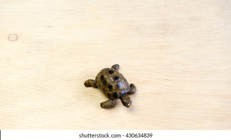 Turtle or tortoise miniature on empty wooden surface. Concept of endangered species. Slightly de-focused and close-up shot. Copy space.