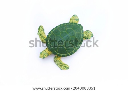 Turtle toy on white background. Green and yellow turtle toy. Artificial turtle toy.