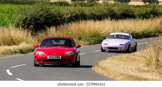 Turvey, Beds, UK - July 16th 2022. 2001 Mazda MX5 followed by a 1995 Mazda MX5