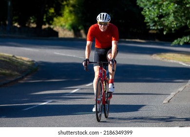 Turvey, Beds, UK - July 16th 2022. Cyclist In Red Lycra Riding Through An English Village