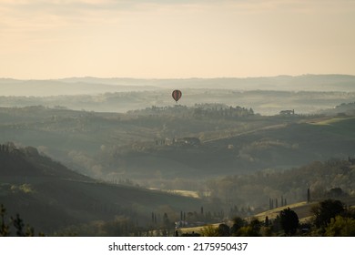 Tuscany landscape with hot air balloon from San Gimignano on a warm spring morning with rolling hills and mountains, Siena, Italy - Powered by Shutterstock