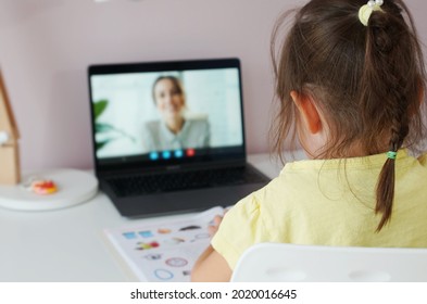 Tutor On Laptop Teaching Child. Pretty Girl At The Lesson. School Teen Girl Student Distance Learning With Online Teacher On Computer Screen. Web Tutor Gives Remote Class Teaching Teen. Over Shoulder.