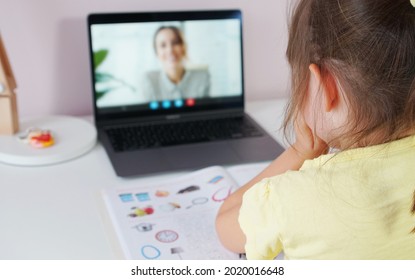 Tutor On Laptop Teaching Child. Pretty Girl At The Lesson. School Teen Girl Student Distance Learning With Online Teacher On Computer Screen. Web Tutor Gives Remote Class Teaching Teen. Over Shoulder.