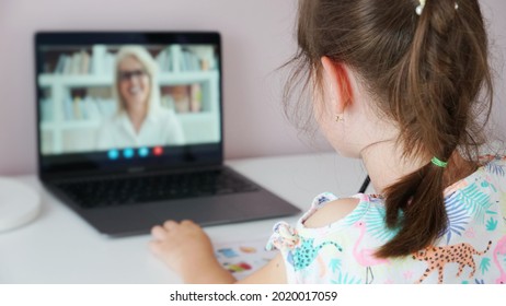 Tutor On Laptop Teaching Child. Pretty Girl At The Lesson. School Teen Girl Student Distance Learning With Online Teacher On Computer Screen. Web Tutor Gives Remote Class Teaching Teen. Over Shoulder.