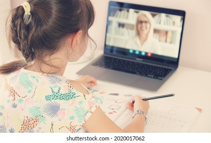 Tutor On Laptop Teaching Child. Pretty Girl At The Lesson. School Teen Girl Student Distance Learning With Online Teacher On Computer Screen. Web Tutor Gives Remote Class Teaching Teen. Over Shoulder.