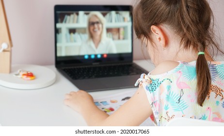 Tutor On Laptop Teaching Child. Pretty Girl At The Lesson. School Teen Girl Student Distance Learning With Online Teacher On Computer Screen. Web Tutor Gives Remote Class Teaching Teen. Over Shoulder.