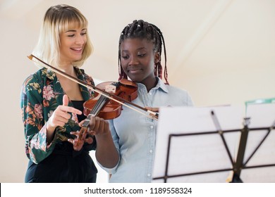 Tutor Teaching High School Student To Play Violin In Music Lesson